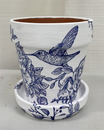 White flower pot with blue hummingbirds and flowers decoupaged on it